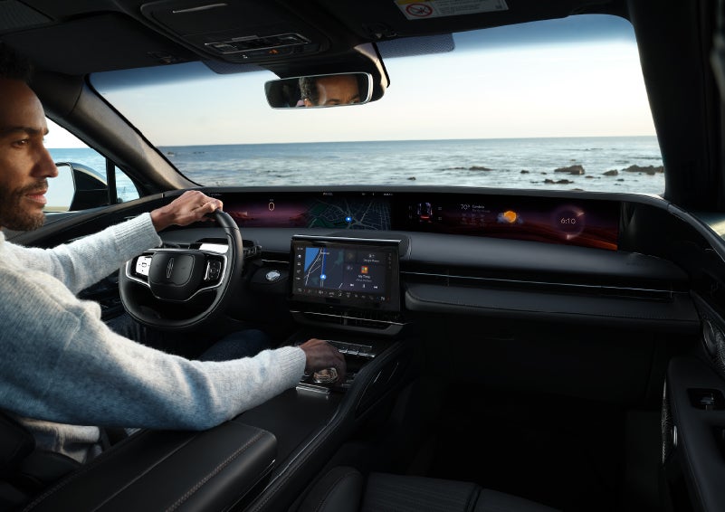 A driver of a parked 2024 Lincoln Nautilus® SUV takes a relaxing moment at a seaside overlook while inside his Nautilus. | Buss Lincoln in McHenry IL